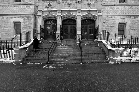 A woman climbing steps of Convent Avenue Baptist Church